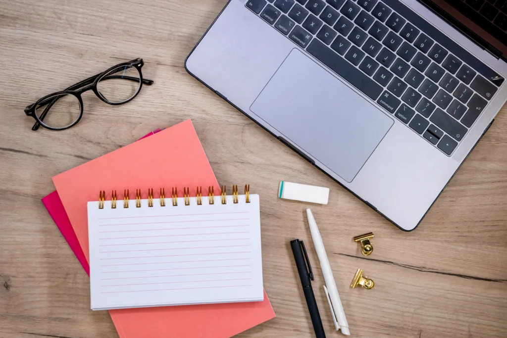 "Escritorio organizado con una agenda, anteojos y una computadora, mostrando la planificación para emprender a los 50 años."